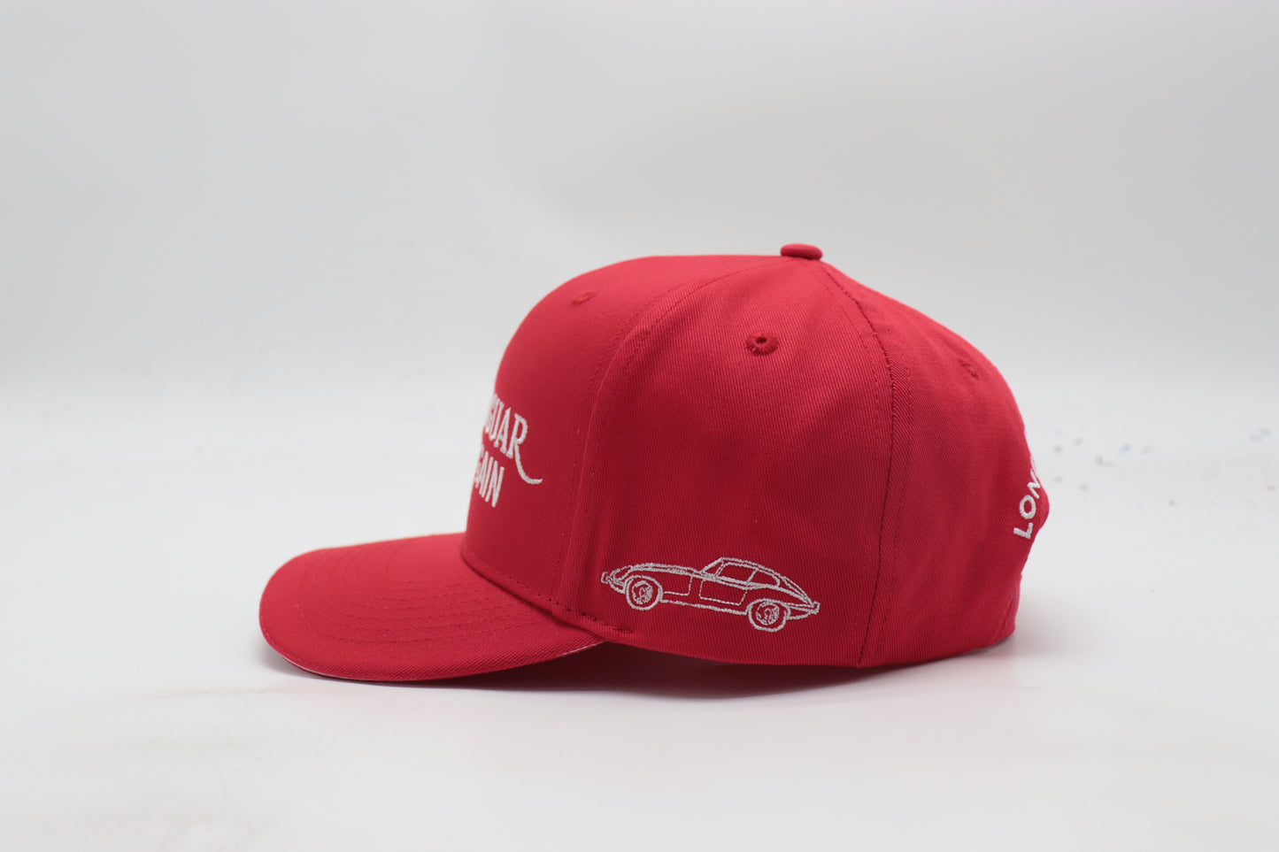 Red cap with white car design and text on a white background